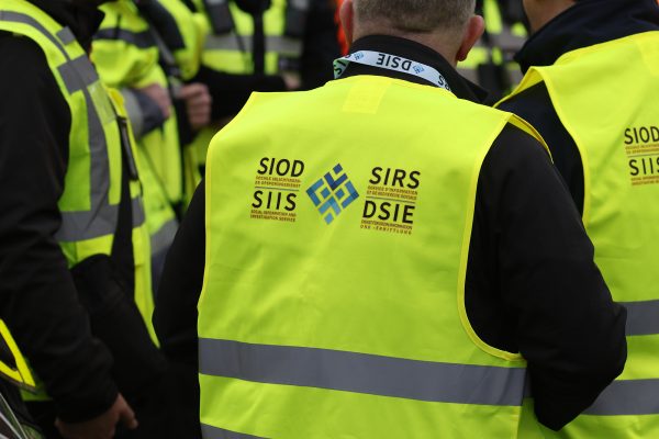 Die Inspektoren des Sozial-Ermittlungsdienstes tragen gelbe Westen mit dem Logo des Dienstes