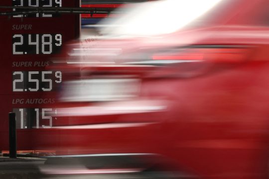 Auto fährt vorbei, im Hintergrund die Anzeigetafel einer Tankstelle mit den Kraftstoffpreisen