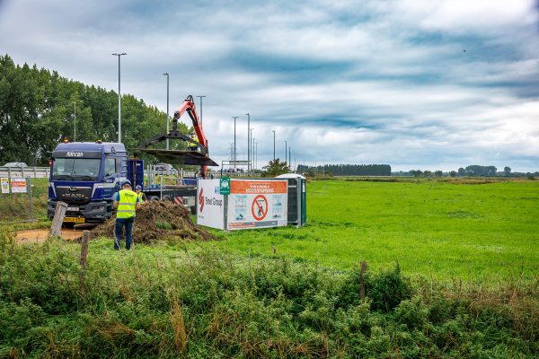 Bauarbeiter mit Kranlader führen erste Arbeiten durch