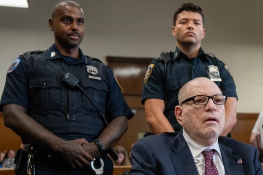 Harvey Weinstein bei der Gerichtsverhandlung in New York, hinter ihm stehen zwei Polizeibeamte
