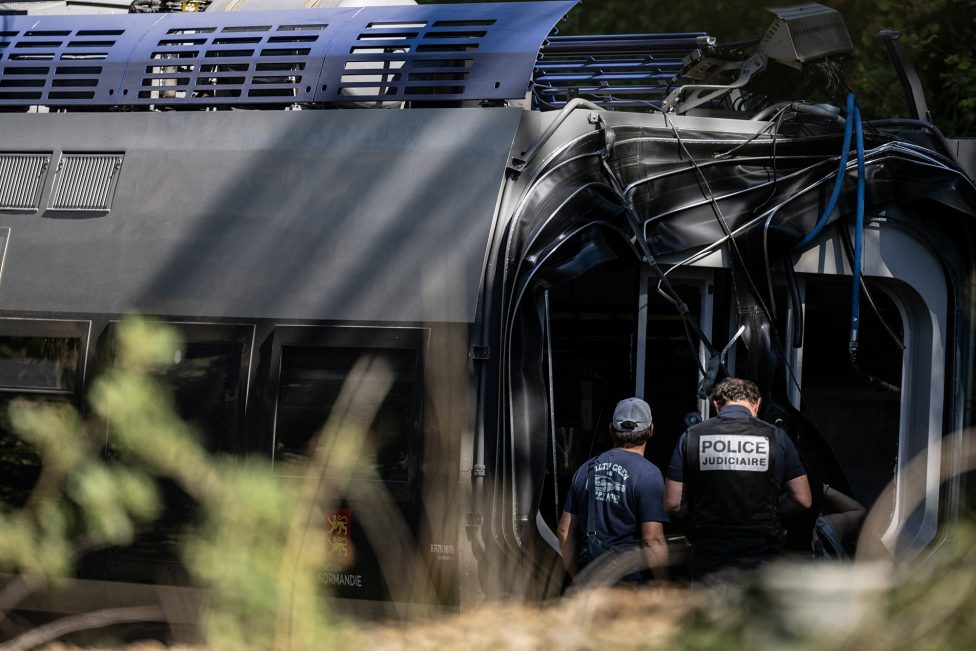 Ermittler der Polizei stehen vor dem entgleisten Zug