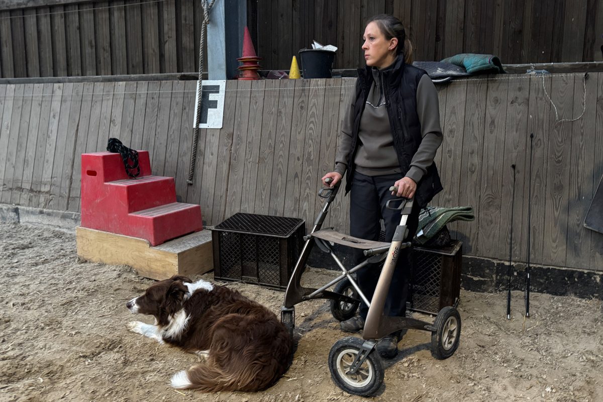 Anne Kirsch mit Rollator und Hund in der Reithalle