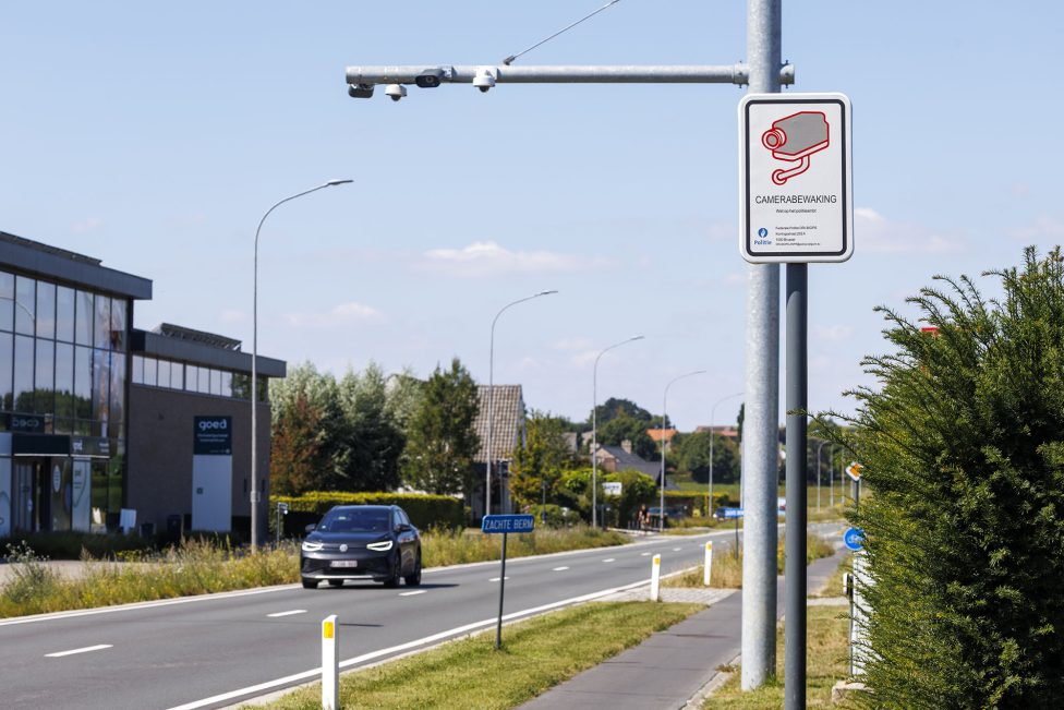 Ein Mast mit einer ANPR-Kamera und einem Schild, das auf die Kameraüberwachung hinweist