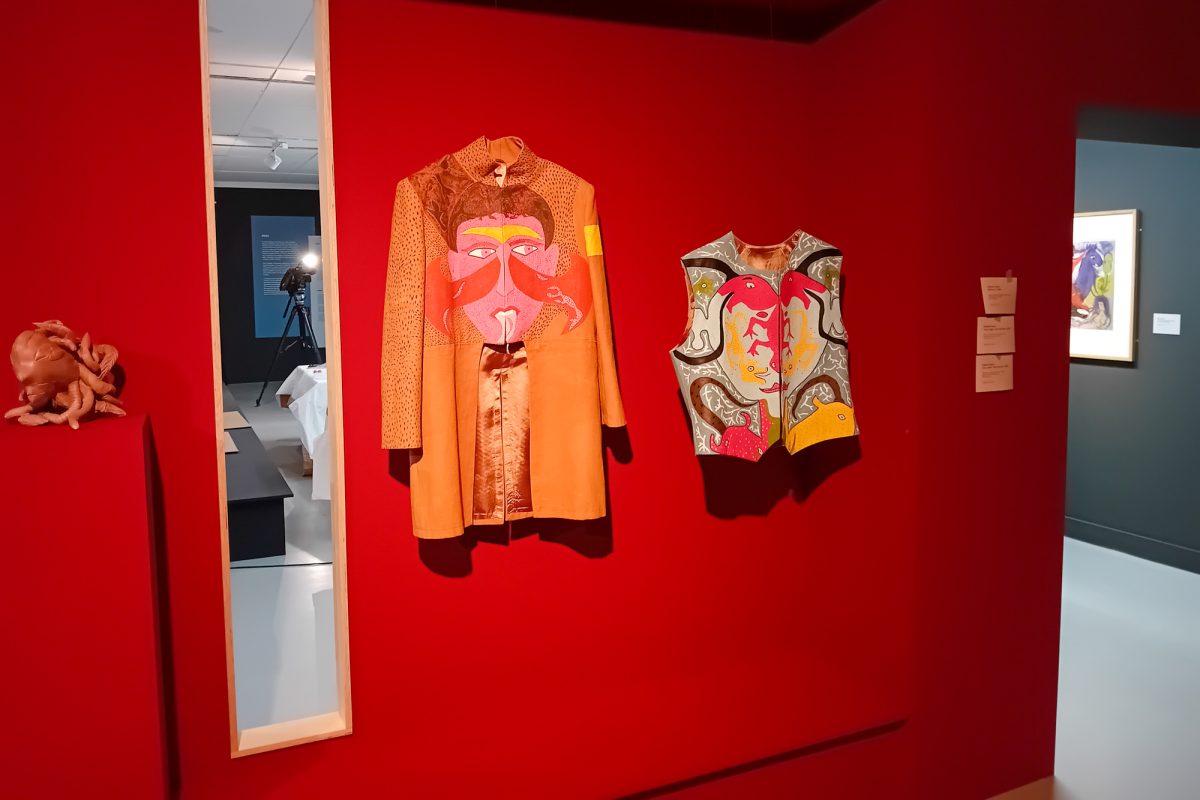 An einer Wand hängen zwei Kleidungsstücke, die mit Bildern bzw. Mustern von Chagall bedruckt sind