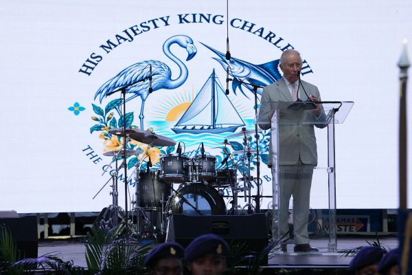 König Charles III. hält auf einer Bühne eine Ansprache, im Hintergrund steht ein Schlagzeug