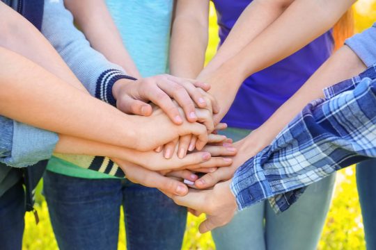 Mehrere Menschen haben ihre Hände aufeinander gestapelt