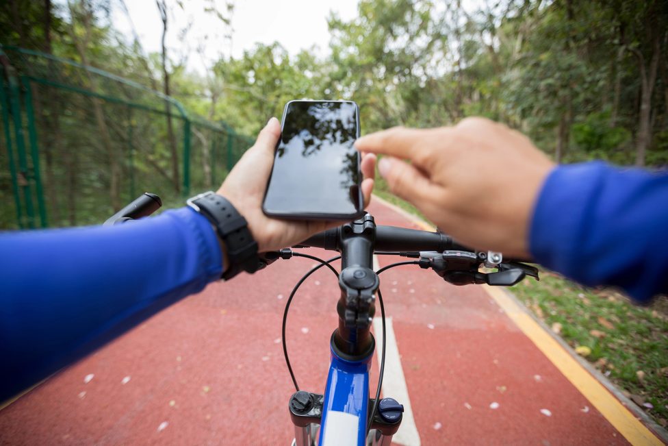 Fahrradfahrer nutzt ein Smartphone während der Fahrt