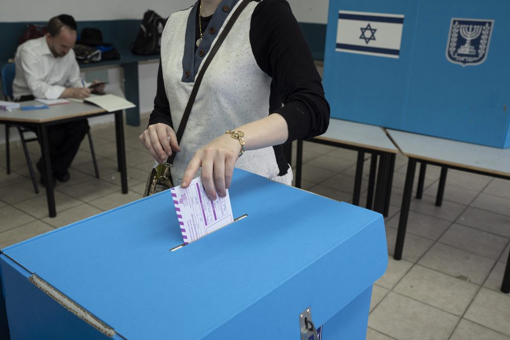 Frau steckt ihren Wahlzettel in einer Urne im Wahlbüro in Bnei Brak