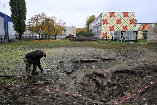 Ein Experte untersucht den Einschlagskrater einer russischen Rakete nahe einer Schule in Kiew