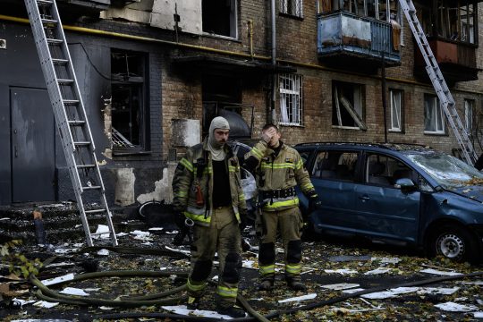 Einsatzkräfte vor einem von Drohnen getroffenen Wohnhaus in Kiew