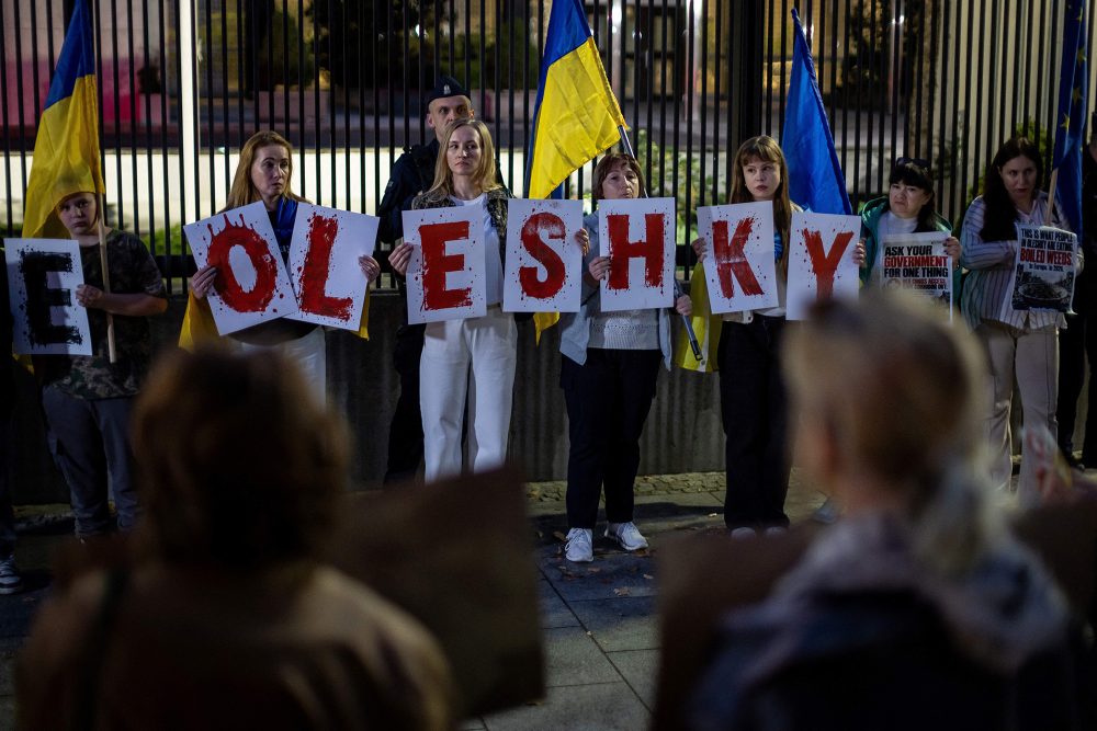 Ukrainer mit Oleschky-Plakat protestieren vor US-Botschaft in Warschau am 6. Oktober 2026