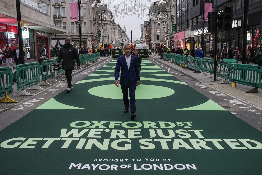 Der Londoner Bürgermeister Sadiq Khan geht über eine Teppich mit der Aufschrift "Oxford Street" zur Eröffnungsfeier der Fußgängerzone