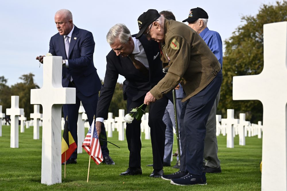 König Philippe legt mit einem der Veteranen Blumen ab
