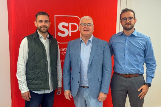 Patrick Spies, Charles Servaty und Lothar Faymonville posieren für ein Gruppenbild, im Hintergrund das Logo der SP