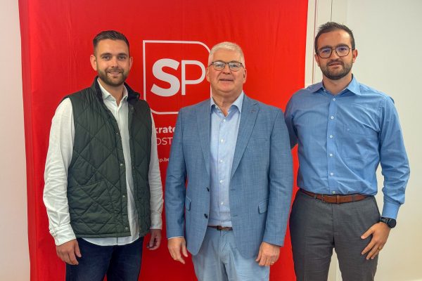 Patrick Spies, Charles Servaty und Lothar Faymonville posieren für ein Gruppenbild, im Hintergrund das Logo der SP