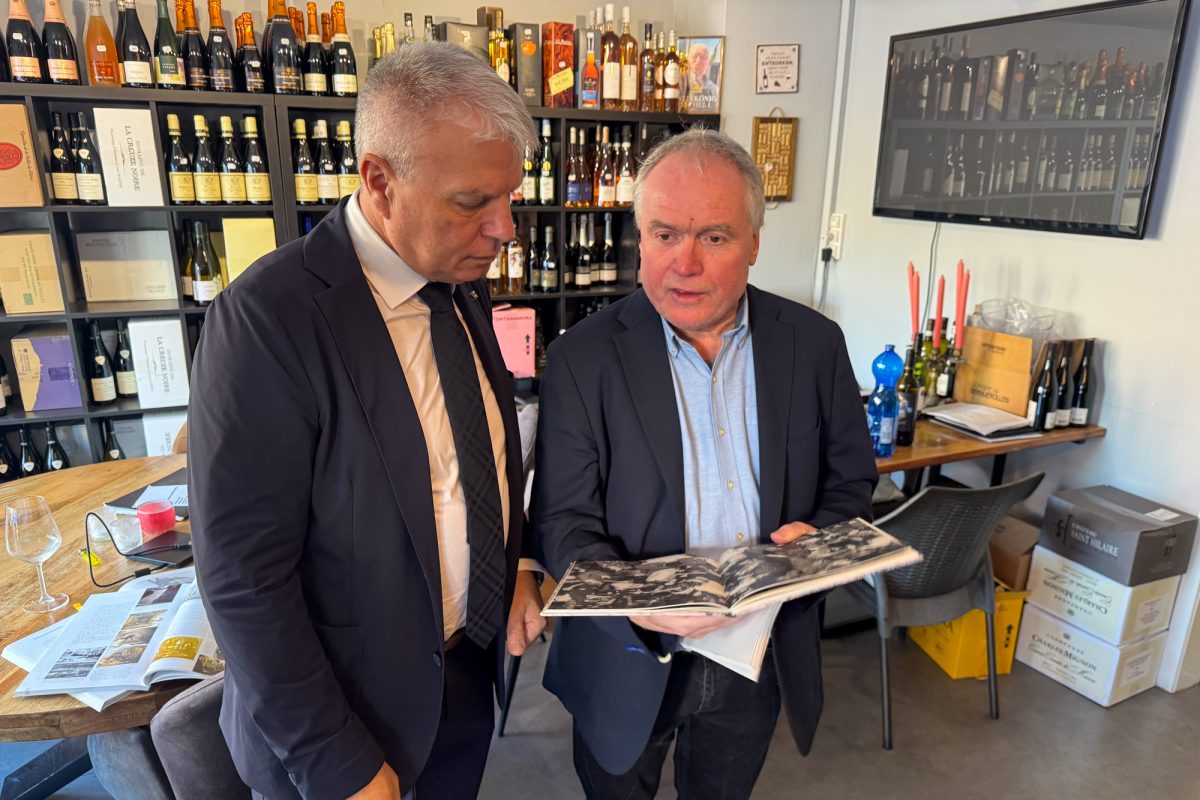 DG-Tourismusminister Gregor Freches und Heribert Krickel schauen sich in den Räumlichkeiten der Vinothek ein Buch an