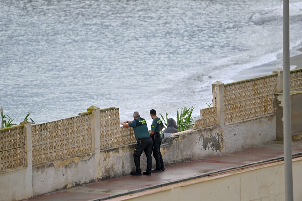 Zwei Beamte der spanischen Guardia Civil schauen auf das Meer