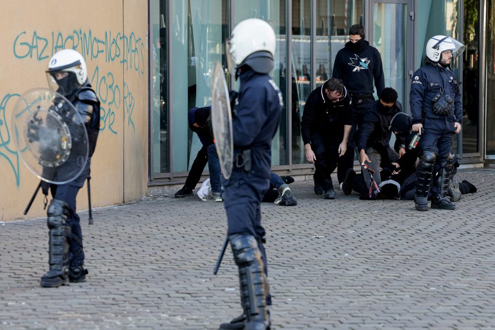 Polizisten versuchen, Krawallmacher ruhig zu stellen