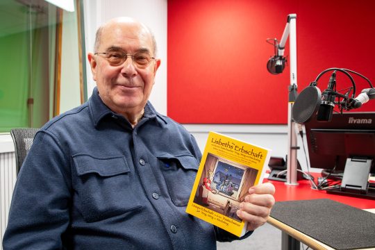 Walter Janssen vom Dorfarchiv Hauset mit dem Buch im BRF-Studio