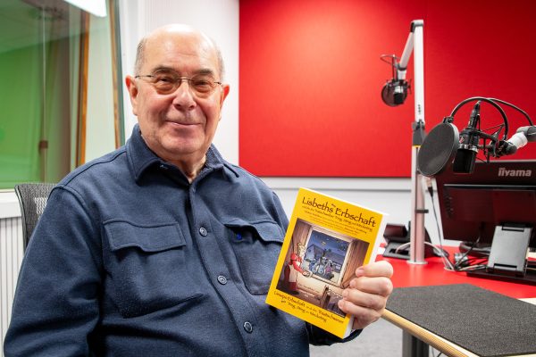Walter Janssen vom Dorfarchiv Hauset mit dem Buch im BRF-Studio