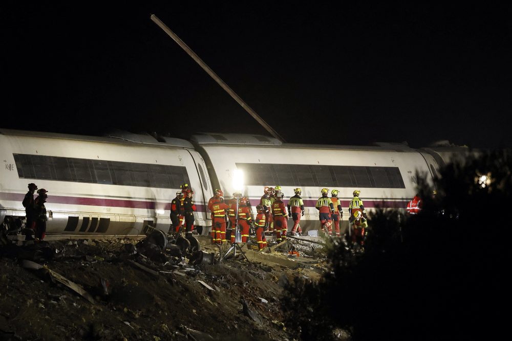 Zahlreiche Retter stehen vor dem verunglückten Zug, es ist dunkel