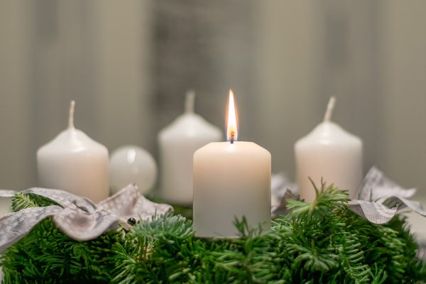 Adventskranz mit einer brennenden Kerze