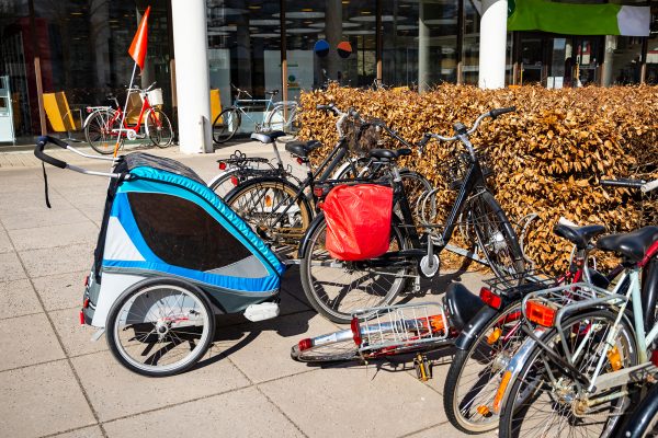 Fahrräder und ein Fahrradanhänger stehen geparkt vor einem Gebäude