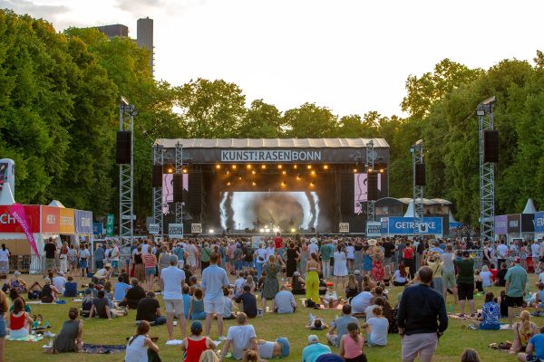 Bühne beim Kunstrasen-Festival in Bonn mit Zuschauern auf der Wiese