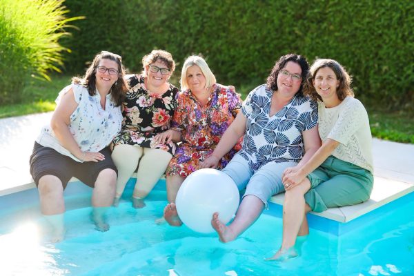 Fünf Frauen sitzen in einem Pool